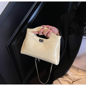 Macro detail of quilted cream leather bag featuring gold twist lock and chain strap