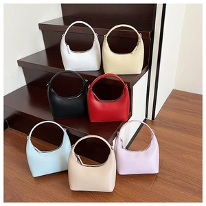Minimalistische Halbmond-Handtaschen aus Kunstleder in sieben Farben auf Holzstufen