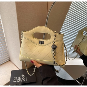 Detail of quilted leather handbag with adjustable chain strap and metallic ball charm