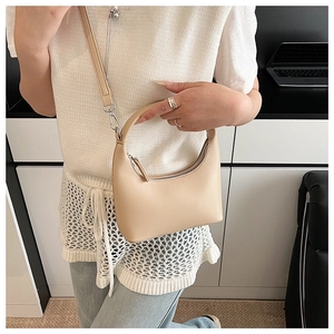 Schicke beige Halbmondtasche am Modell zur Darstellung der Größe und des Stils