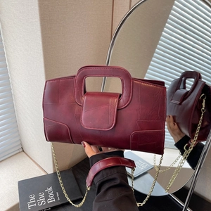 Vintage burgundy patchwork leather handbag with a gold chain strap and top handle