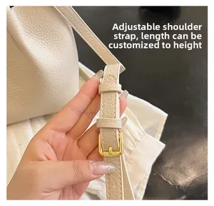 Detail of adjustable beige lychee leather strap with gold buckle for tote bag