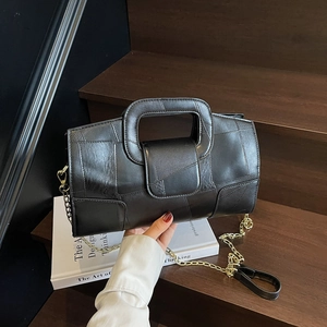 French design black patchwork leather handbag with gold chain strap on wooden steps