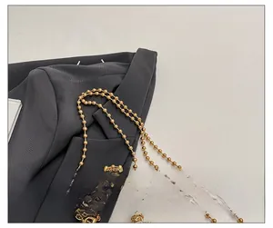 Detail of the golden metal beaded chain strap with lobster clasp for fashion bags