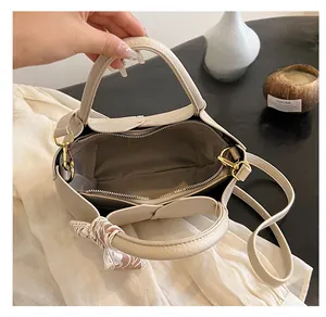 Detailed interior of beige tote bag showing zippered compartments and silk scarf handles