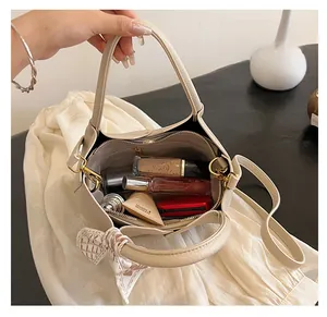 Macro view of beige lychee leather tote interior with cosmetics and silk scarf detail