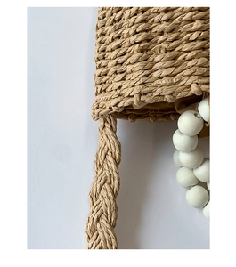 Detailed macro shot of natural woven texture with white decorative beads and braided strap
