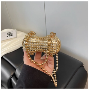 Detail of peanut-shaped evening bag with gold crystals and delicate metal bead chain