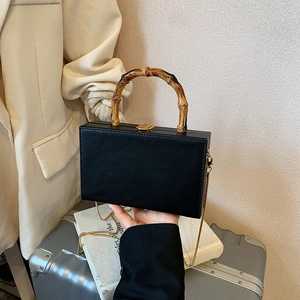 Elegant black hard shell box bag with bamboo handle and gold chain shoulder strap