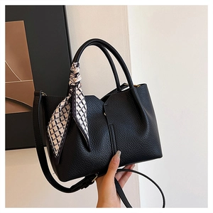 Close-up of black lychee grain leather tote bag with stylish geometric silk scarf detail