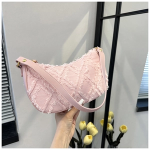 Close-up of pink denim hobo bag with quilted frayed edges and golden rivets