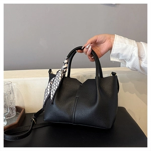 Detail of black lychee grain leather tote bag with V-cut top and decorative silk scarf