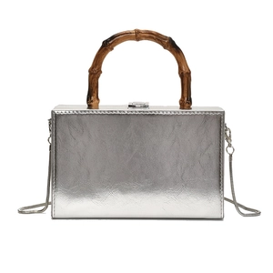 Silver structured box bag with bamboo handle and metal chain strap on white background