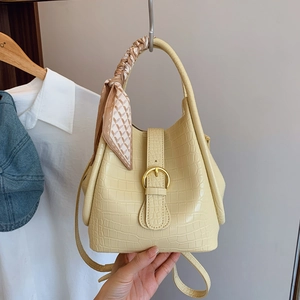 Cream bucket bag with crocodile texture, gold horsebit buckle and silk scarf handle