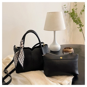 Close-up of black lychee grain tote bag with decorative scarf and gold hardware detail
