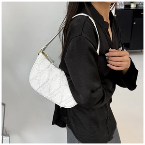 Detail of white quilted tote bag with fringe texture shown on model's shoulder