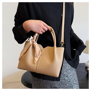 Detail of beige lychee grain tote bag with silk scarf handle and adjustable strap