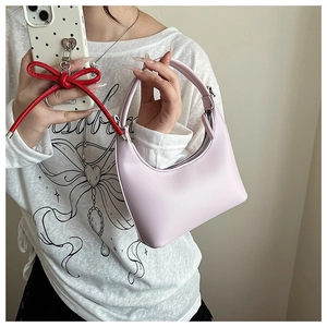 Rosa sichelförmige Handtasche mit Silberreißverschluss, von Model in Hand gehalten