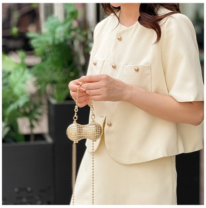 Detail of peanut-shaped evening bag with gold metal frame and sparkling crystals