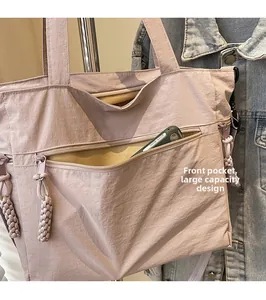 Detail of light pink canvas tote bag featuring a functional large front zipper pocket