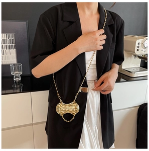 Detailed view of a gold peanut-shaped crossbody bag with rhinestones and bead chain