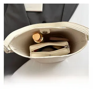 Interior view of crocodile pattern bucket bag with small pouch and metal magnetic clasp