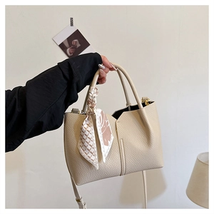 Detail of beige lychee leather tote bag with geometric silk scarf wrapped handle