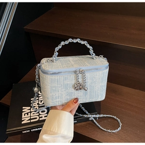Close-up of light blue textured chain bag featuring a 3D silver rose pendant charm