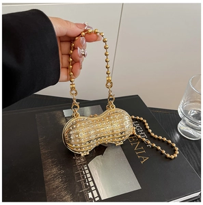 Detailed close-up of a luxury gold peanut-shaped evening bag with sparkling rhinestones