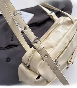 Détails du sac moto blanc cassé avec double fermeture éclair et bandoulière à rivets