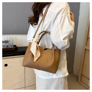 Detail of tan lychee grain tote bag with decorative silk scarf on the handle