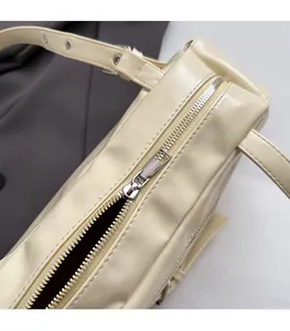 Détail de la fermeture éclair en métal argenté et du cuir PU crème sur sac à main