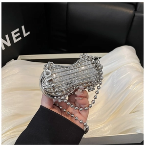 Close-up of a silver peanut-shaped evening clutch bag with full rhinestone embellishments