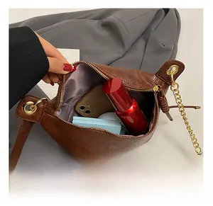 Detail view of the brown vintage crossbody bag internal capacity with purple lining
