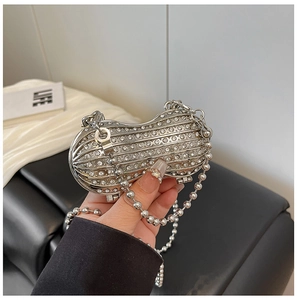 Detailed close-up of a silver peanut-shaped evening bag with crystals and a bead chain