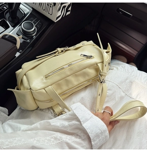 Détails du sac de style motard beige avec rivets et fermetures éclair métalliques