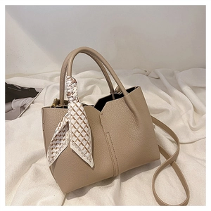 Detail of high-quality lychee texture leather tote bag with stylish decorative scarf