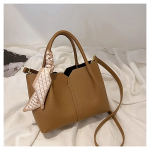 Detailed texture of brown lychee grain leather tote bag with decorative silk scarf