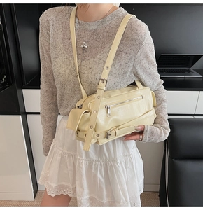 Détail du sac à bandoulière crème avec rivets argentés et boucles métalliques élégantes