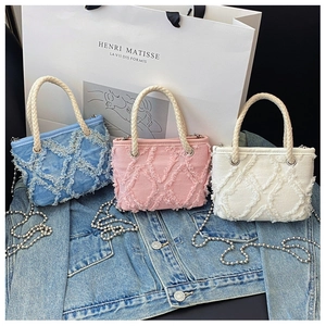Détail de mini sacs en toile avec bordures à franges, poignées tressées et chaînes