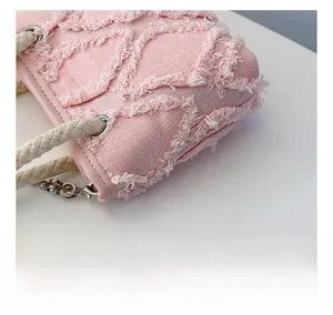 Détail du tissu en toile rose avec texture jacquard et poignée en corde tressée pour enfant