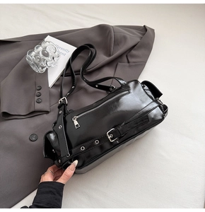 Détail d'un sac à bandoulière en similicuir noir brillant avec rivets et boucles argentés