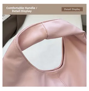 Detail view of the wide, soft handle and fine stitching on the pink underarm bag