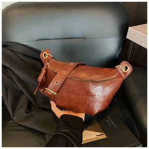 Detail of vintage dark brown faux oil wax leather belt bag with antique gold metal hardware