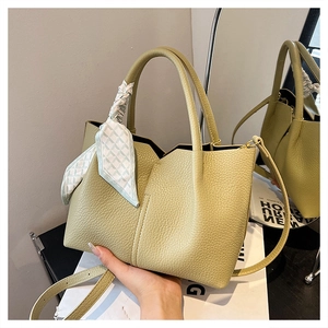 Detail of light green pebbled leather tote with decorative silk scarf and thin strap