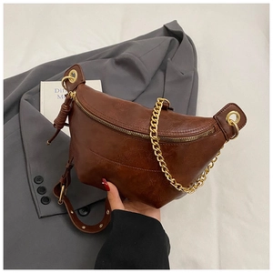 Detail of vintage brown PU leather chest bag featuring gold chain and textured finish