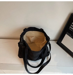 Detail of black tote bag interior showing spacious compartments and brown lining