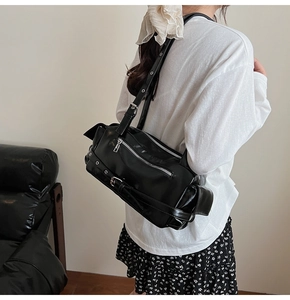 Détail du sac de moto noir à rivets avec zips argentés et sangle à œillets métalliques