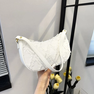 White frayed canvas crescent shoulder bag with quilted texture and gold hardware detailing