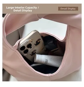 Macro shot of spacious inner capacity of pink dumpling bag with phone and cosmetics